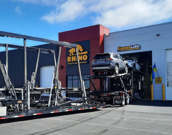 Truck loaded with cars entering a Rhyno workshop bay