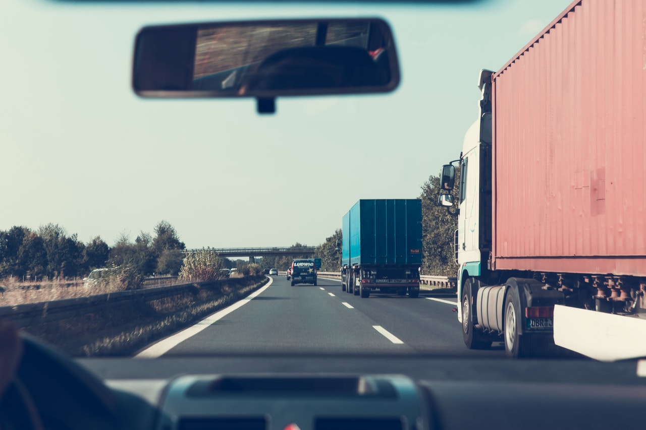 Car driving beside trucks