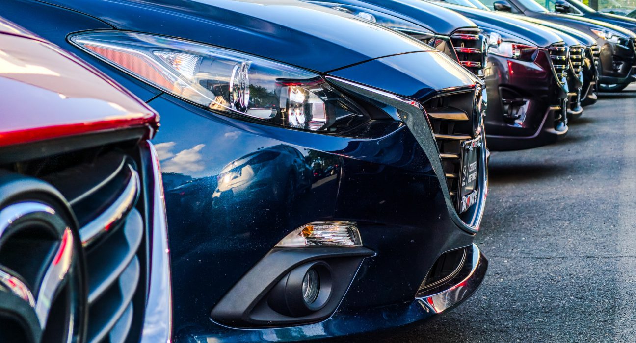 A row of cars at a used car dealership.