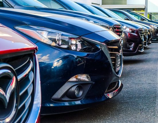 A row of cars at a used car dealership.